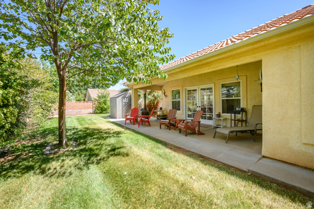 3034 Swiss Drive Santa Clara, UT 84765 - Photo 5 of 59 Expansive backyard featuring a covered patio with concrete flooring, stucco exterior, multiple windows, and a mature tree