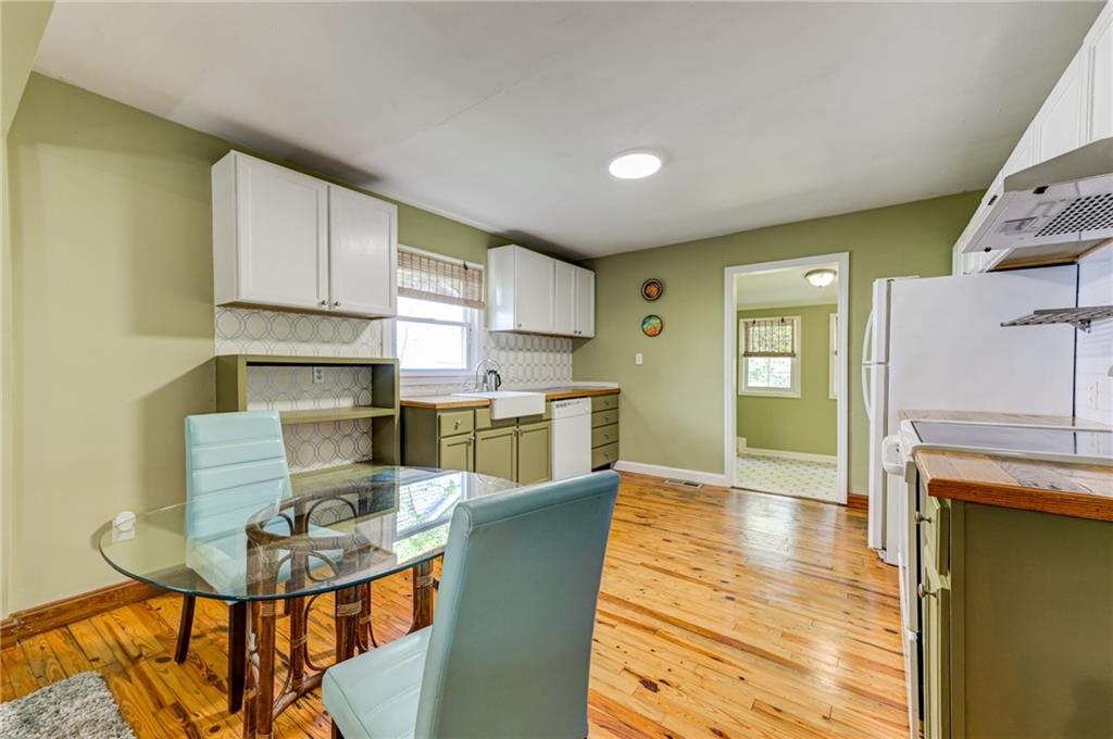 4100 Adrian Street Tucker, GA 30084 - Photo 7 of 23 a kitchen with stainless steel appliances kitchen island granite countertop a dining table chairs and a refrigerator