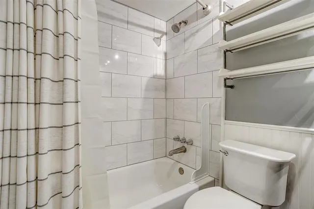 a bathroom with a toilet and shower
