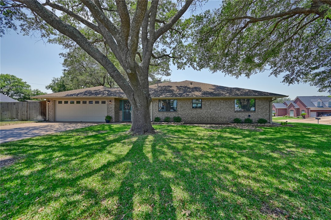 1600 Pecan Street Brenham, TX 77833 - Photo 4 of 33 Home featuring an attached garage, concrete driveway, lock gate to the breezeway. large oak trees and privacy fence