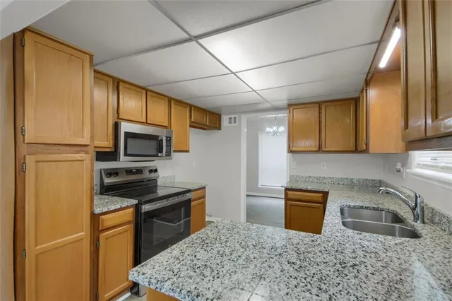 a kitchen with stainless steel appliances granite countertop a sink stove and cabinets