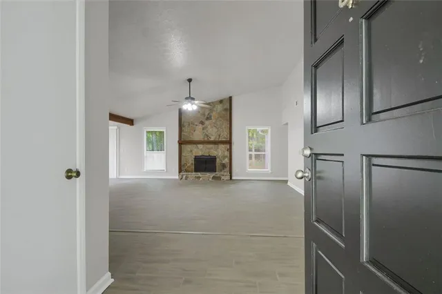 an empty room with windows and fireplace