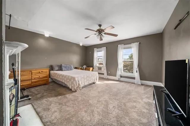 a bedroom with a bed and a flat tv screen on dresser