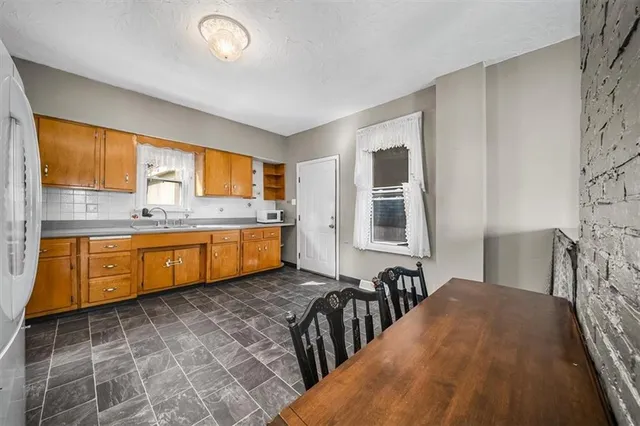 a large kitchen with stainless steel appliances granite countertop a stove a sink and a microwave