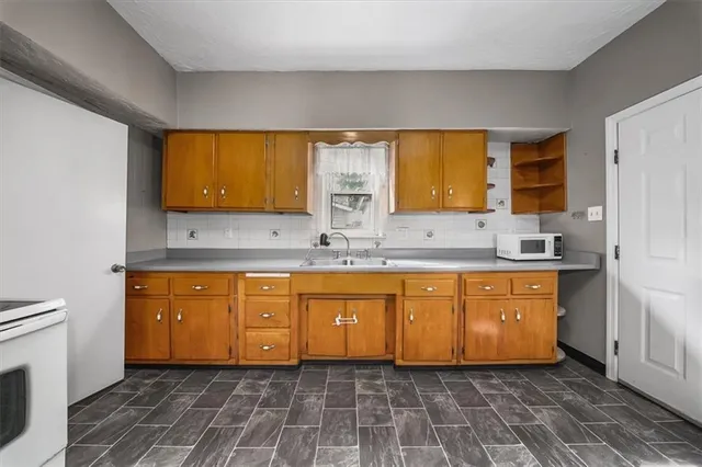 a bathroom with a granite countertop sink a mirror and a bathtub