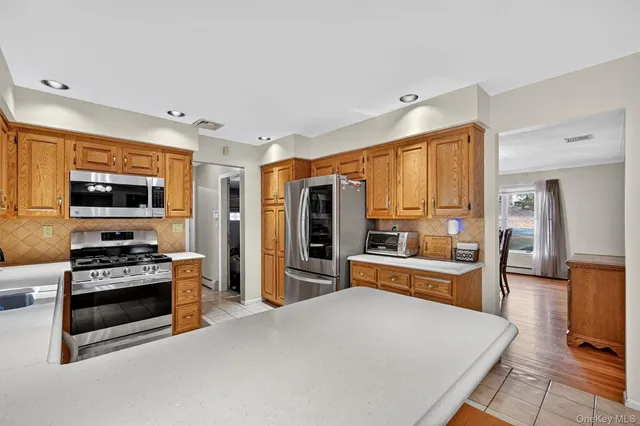 a large kitchen with stainless steel appliances a stove a refrigerator and a stove top oven