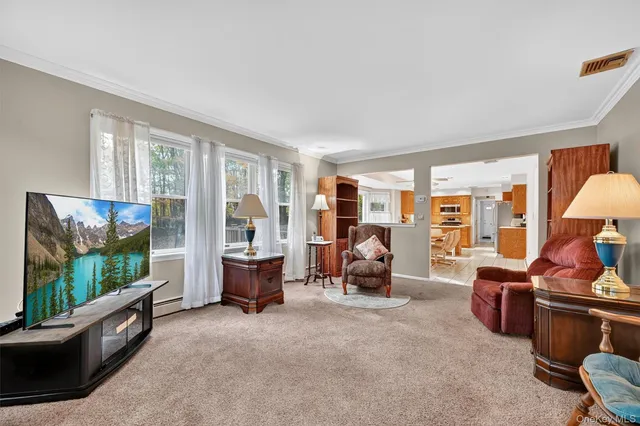 a living room with furniture floor to ceiling window and a flat screen tv