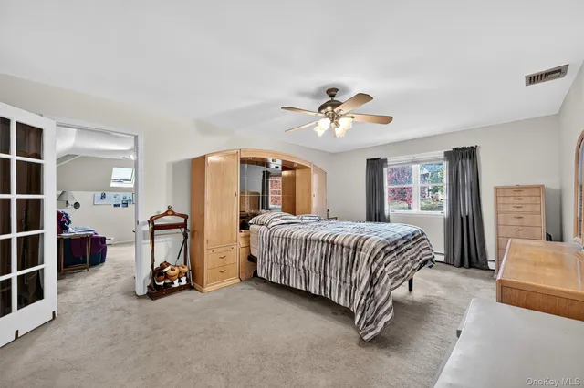 a spacious bedroom with a bed and a chandelier