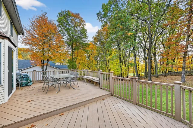 a view of a deck with wooden floor and fence with a large window