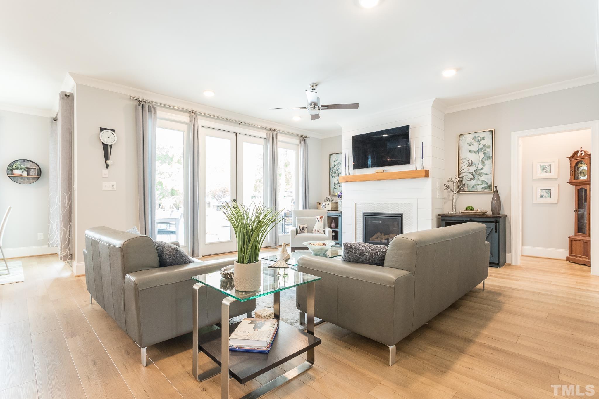 9117 Penny Road Raleigh, NC 27606 - Photo 12 of 54 a living room with furniture a flat screen tv and a fireplace