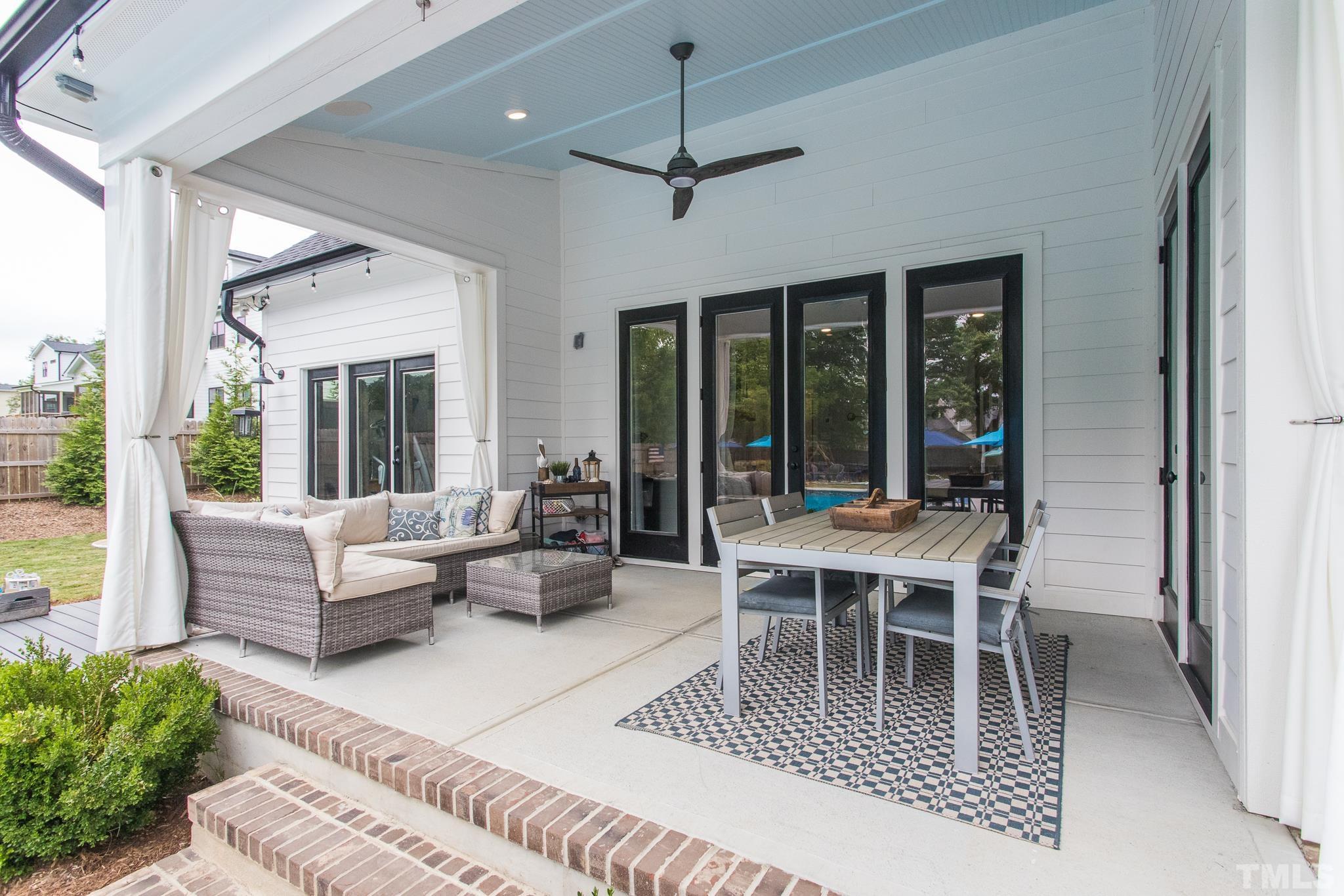 9117 Penny Road Raleigh, NC 27606 - Photo 31 of 54 a dining room with wooden floor a chandelier a glass table and chairs