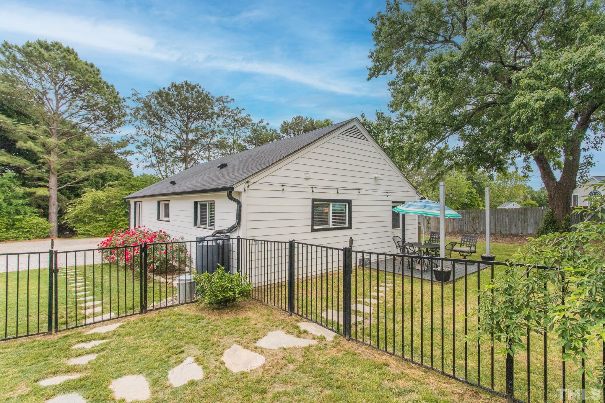 9117 Penny Road Raleigh, NC 27606 - Photo 37 of 54 a view of a house with a wooden deck next to a yard