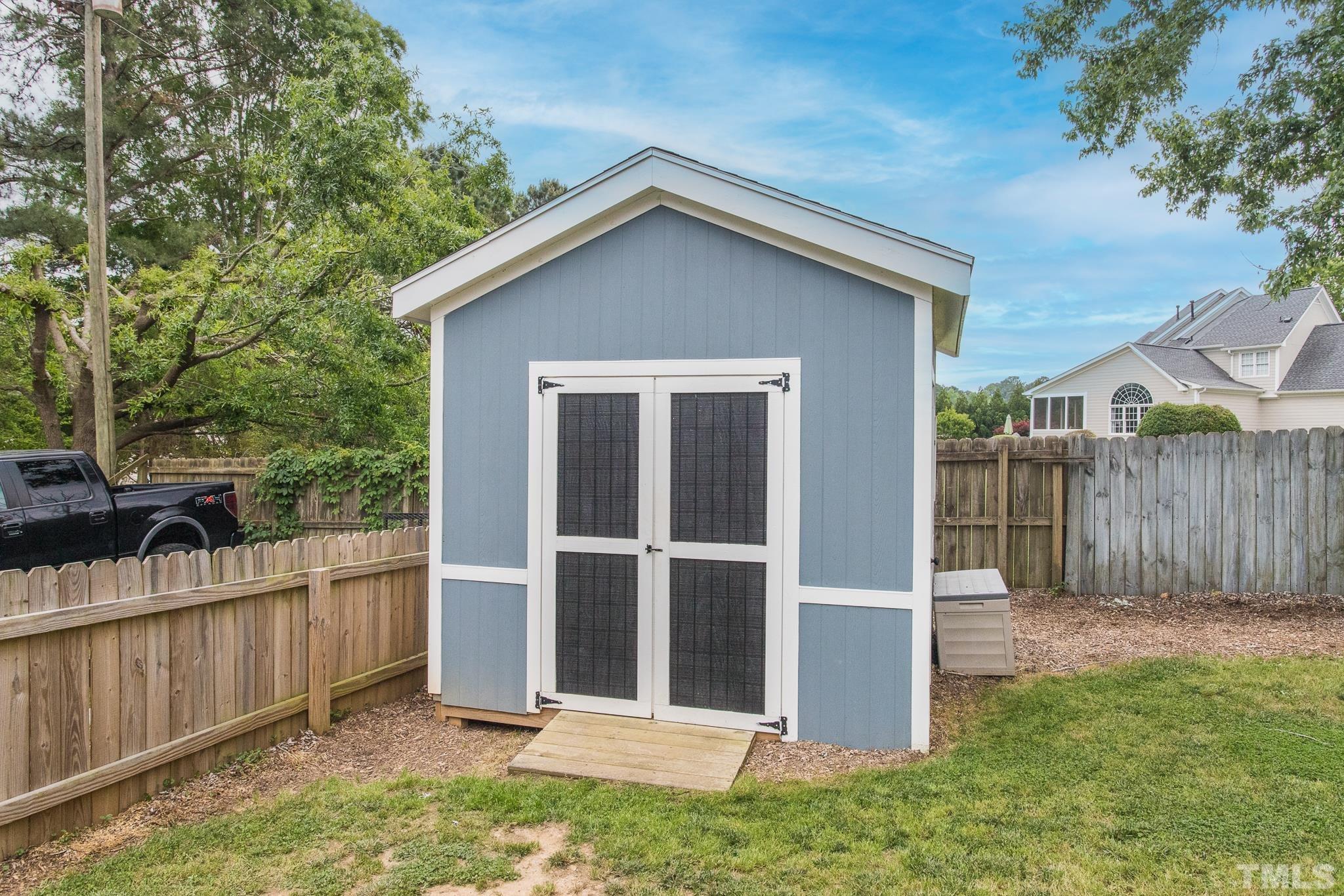 9117 Penny Road Raleigh, NC 27606 - Photo 40 of 54 a view of backyard with small cabin and wooden fence