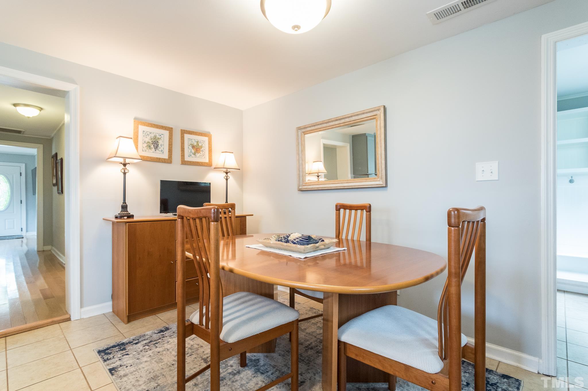 9117 Penny Road Raleigh, NC 27606 - Photo 43 of 54 a view of a dining room with furniture and wooden floor