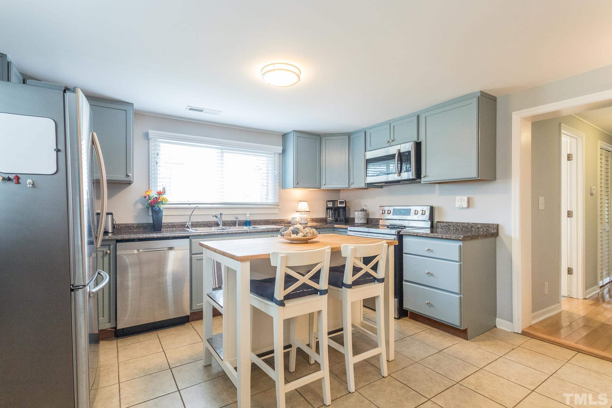 9117 Penny Road Raleigh, NC 27606 - Photo 44 of 54 a kitchen with a stove a sink and a refrigerator