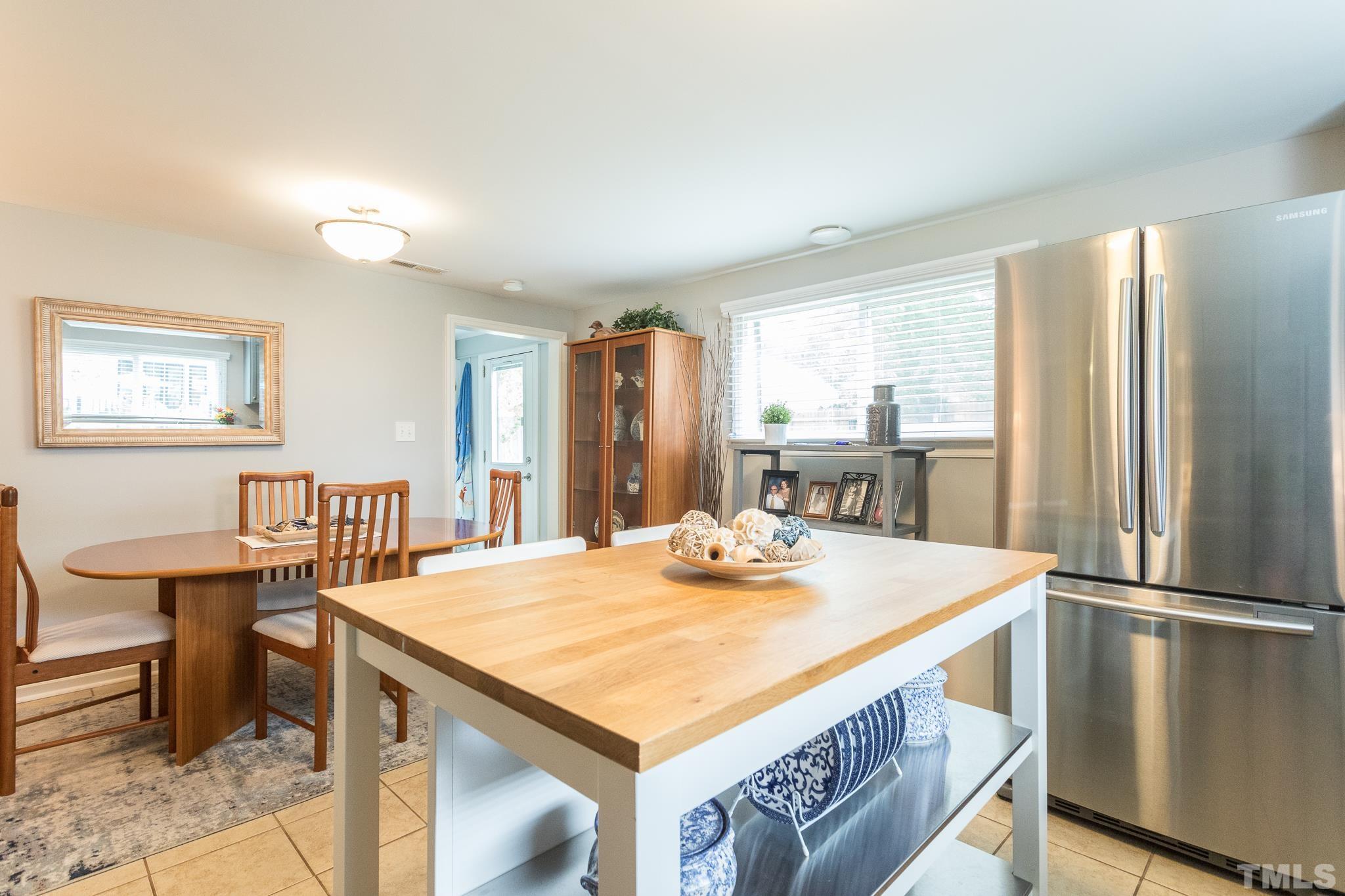9117 Penny Road Raleigh, NC 27606 - Photo 46 of 54 a kitchen with stainless steel appliances granite countertop a table chairs and a refrigerator