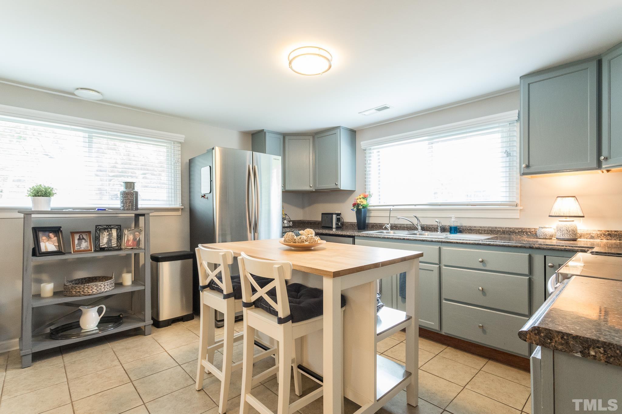 9117 Penny Road Raleigh, NC 27606 - Photo 47 of 54 a kitchen that has a lot of cabinets in it with a dining table and chairs