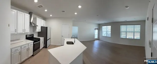 a kitchen with stainless steel appliances a refrigerator sink and cabinets