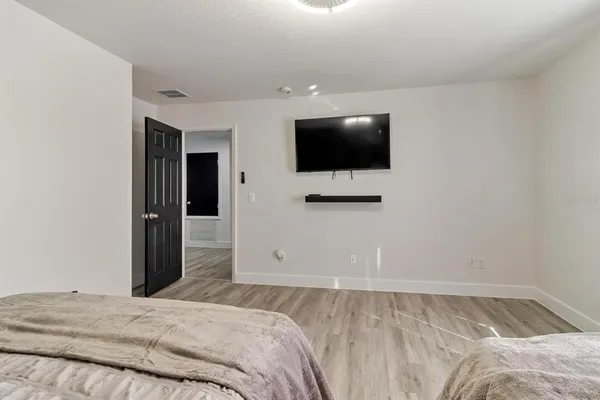 a bedroom with a bed and a flat screen tv