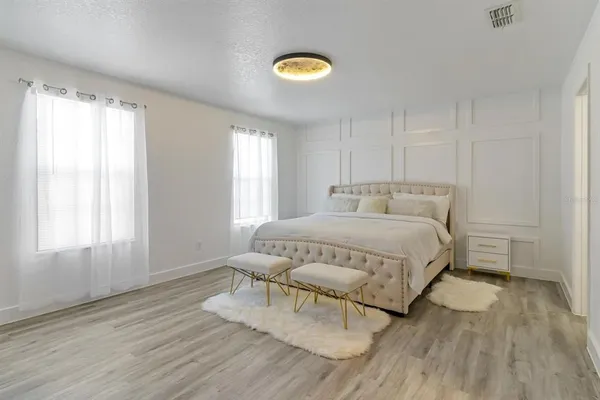 a spacious bedroom with a bed and a window