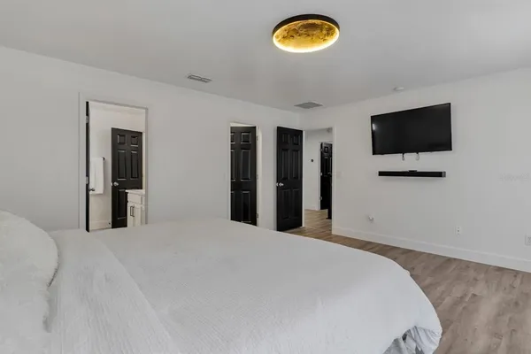 a bedroom with a bed and a flat screen tv