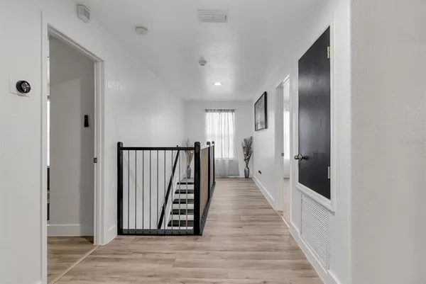 a view of a hallway with wooden floor and staircase