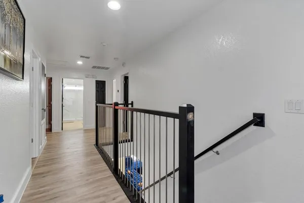 a view of a hallway with wooden floor and staircase