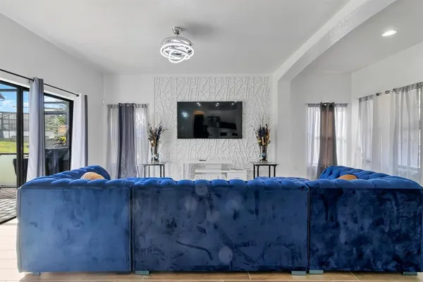 a living room with a bed furniture and a flat screen tv