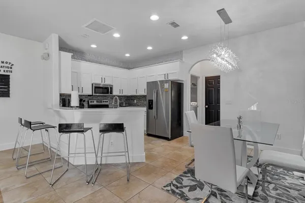 a kitchen with stainless steel appliances kitchen island granite countertop a refrigerator and a stove top oven