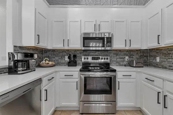 a kitchen with cabinets appliances and a sink