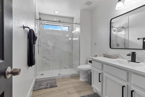 a bathroom with a granite countertop sink toilet and shower