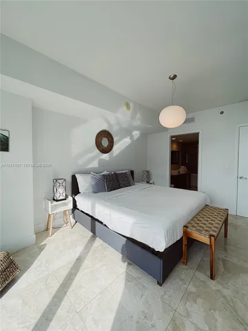 a bedroom with a bed and a chandelier