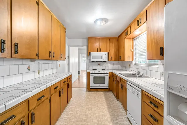a kitchen with stainless steel appliances granite countertop a sink a stove and a refrigerator