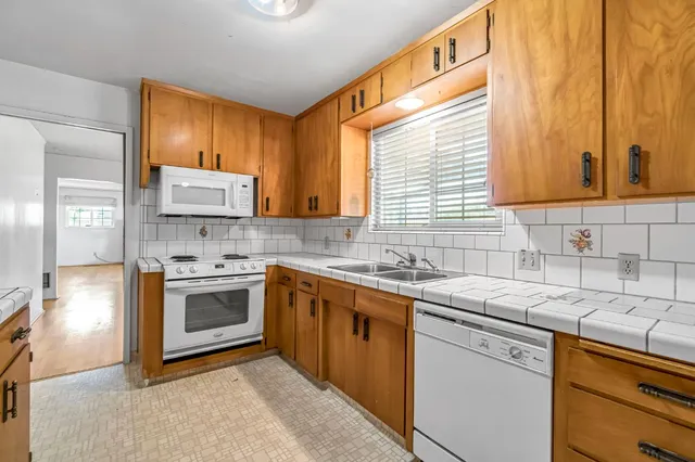 a kitchen with stainless steel appliances granite countertop a sink stove and cabinets