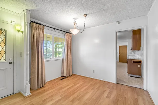 wooden floor in an empty room with a bathroom