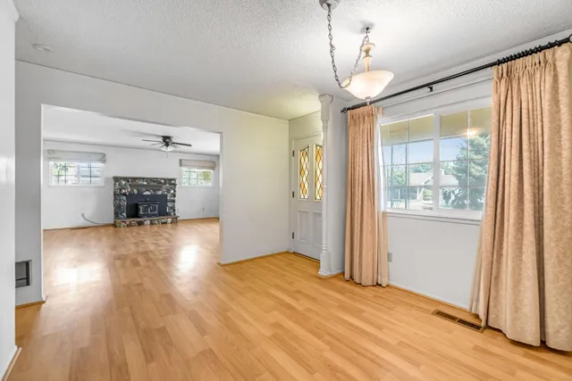 a view of empty room with wooden floor and fireplace