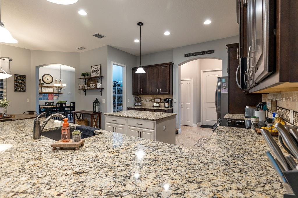 316 Old Mill Road Deltona, FL 32725 - Photo 11 of 64 a large kitchen with stainless steel appliances granite countertop a sink refrigerator and cabinets