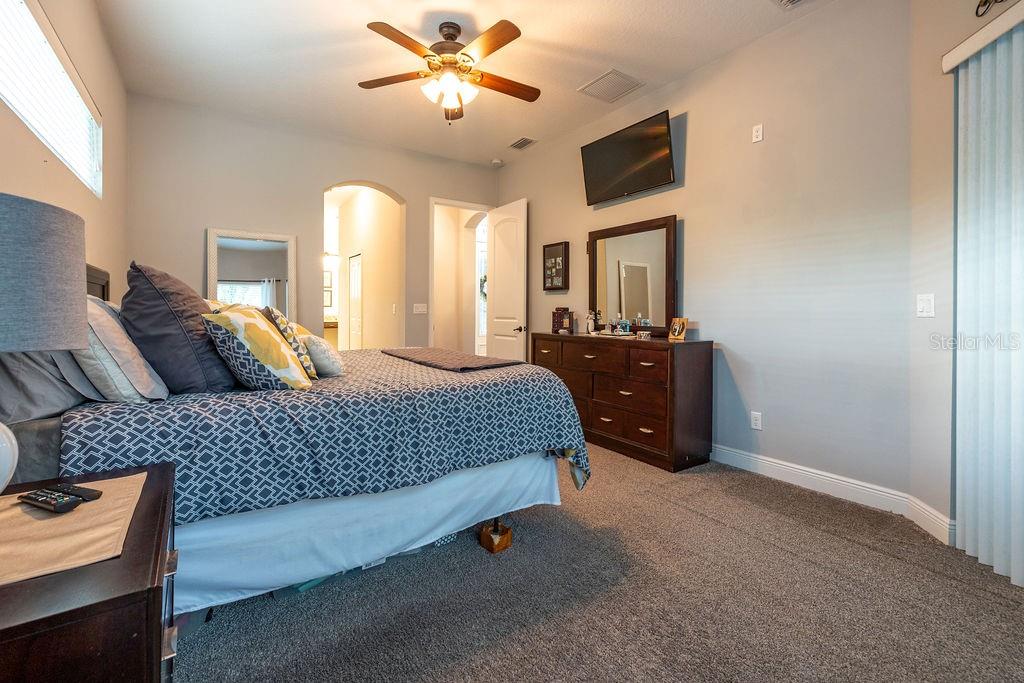 316 Old Mill Road Deltona, FL 32725 - Photo 19 of 64 a bedroom with a bed and a chandelier