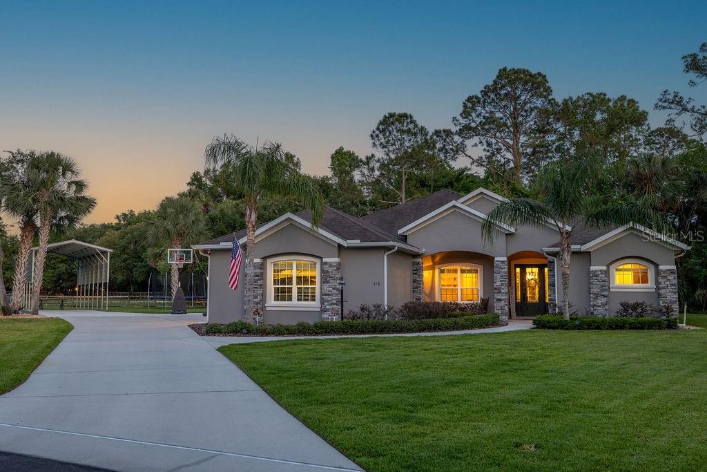 316 Old Mill Road Deltona, FL 32725 - Photo 2 of 64 a front view of a house with a garden and yard