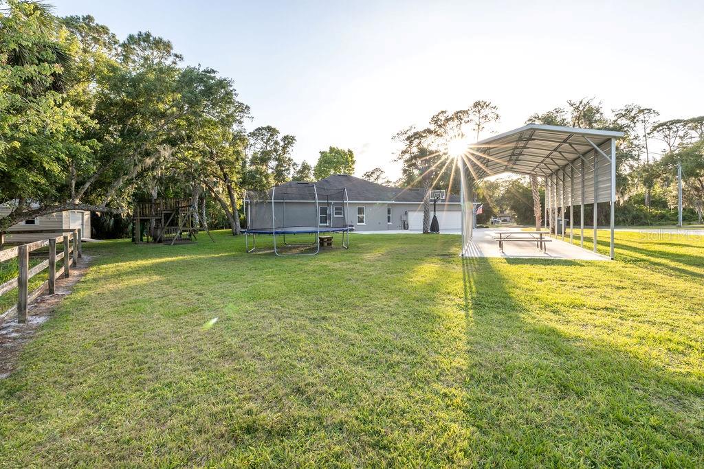 316 Old Mill Road Deltona, FL 32725 - Photo 36 of 64 a view of a swimming pool with a lawn chairs and plants