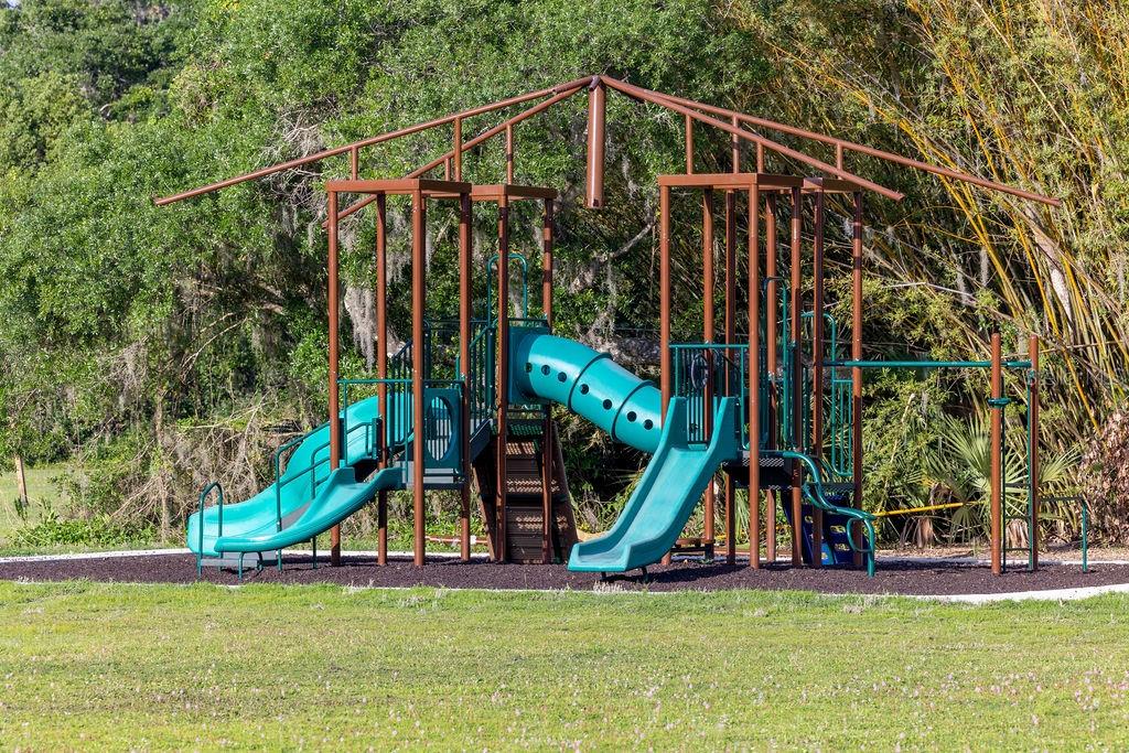 316 Old Mill Road Deltona, FL 32725 - Photo 51 of 64 a view of a park with a bench and potted plants