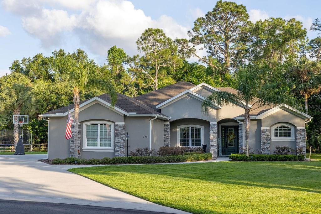 316 Old Mill Road Deltona, FL 32725 - Photo 52 of 64 a front view of a house with a garden