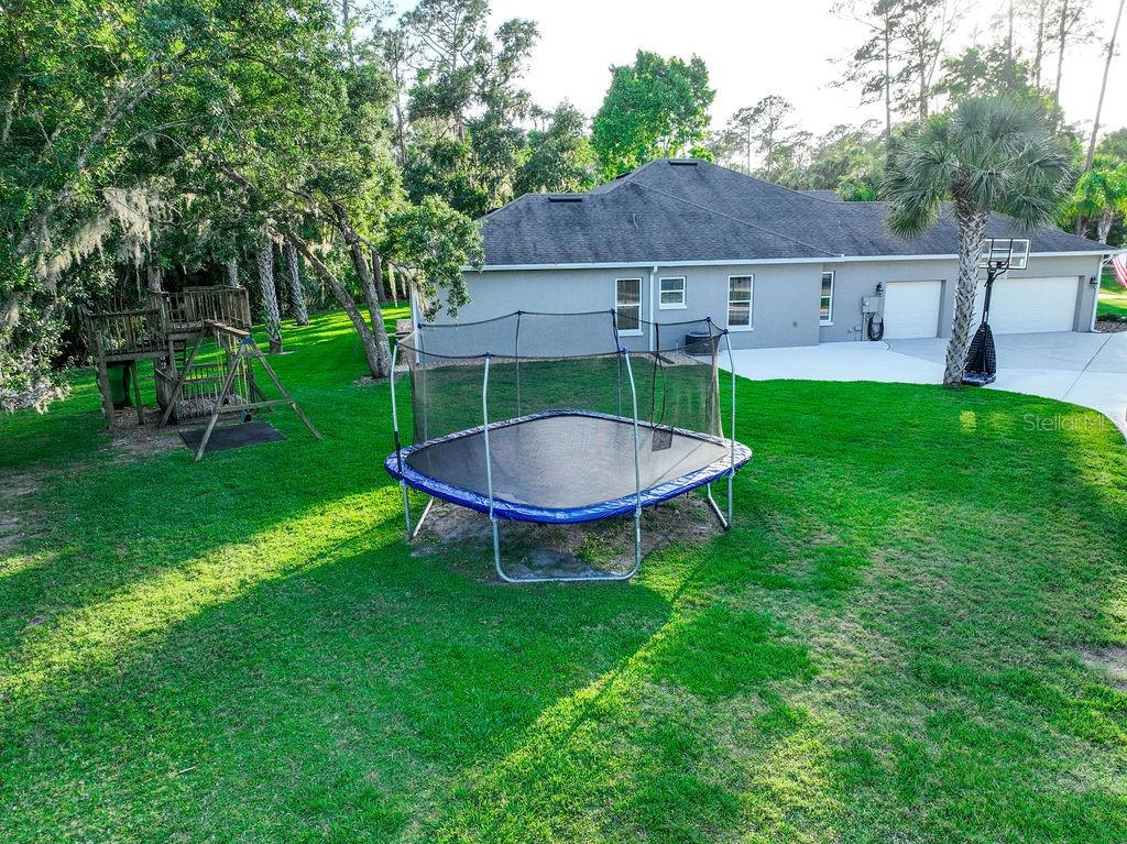 316 Old Mill Road Deltona, FL 32725 - Photo 62 of 64 a view of a backyard with plants and a slide