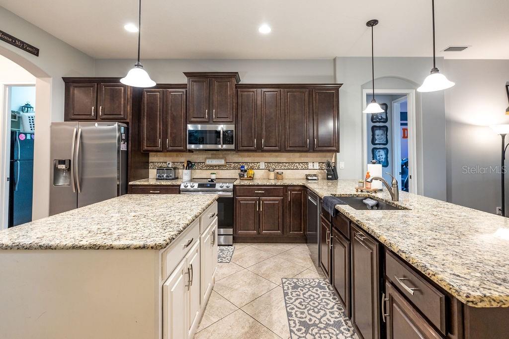 316 Old Mill Road Deltona, FL 32725 - Photo 9 of 64 a kitchen with stainless steel appliances granite countertop a sink stove and refrigerator