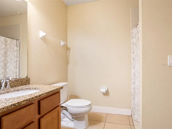 a bathroom with a granite countertop sink a toilet and a mirror