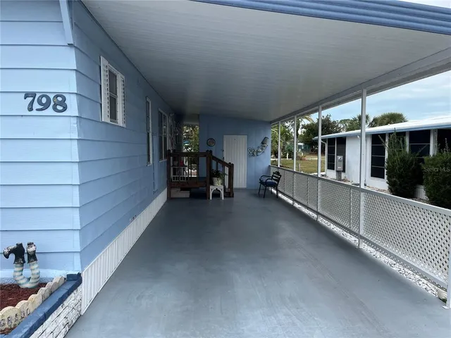 a view of a porch with furniture and a yard
