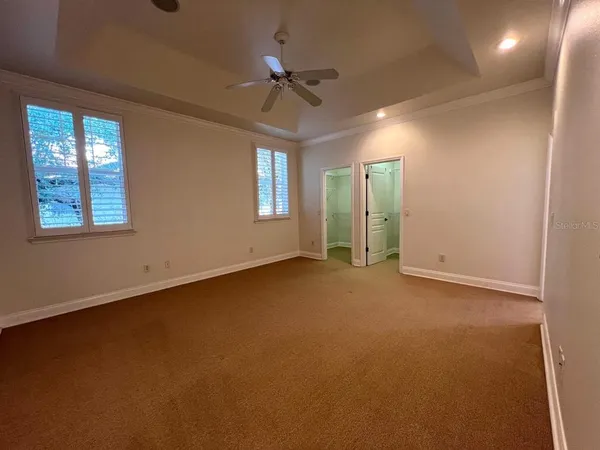 an empty room with a ceiling fan and window