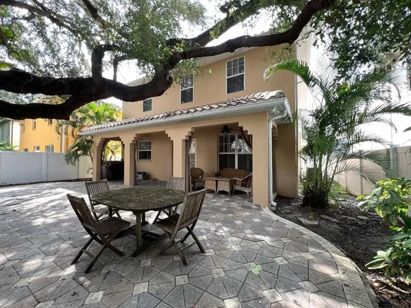 a view of a house with backyard and sitting area