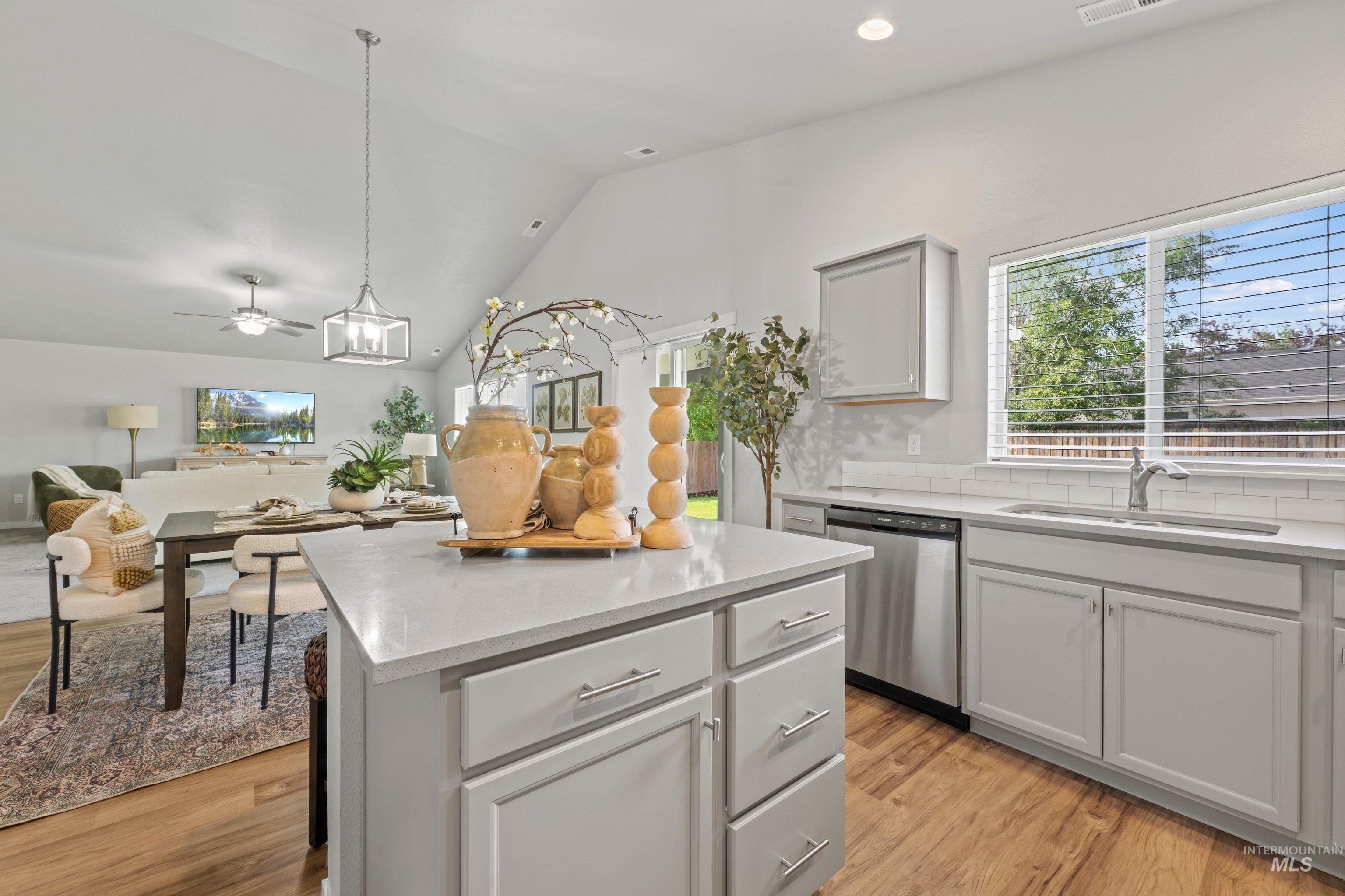 12744 West Fig Street Boise, ID 83713 - Photo 15 of 34 Kitchen featuring a central island with countertop, light gray cabinetry, stainless steel sink, and a matching dishwasher