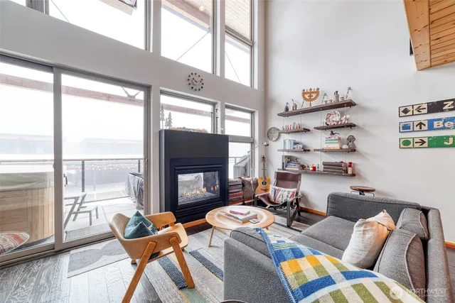 a living room with furniture a flat screen tv and a floor to ceiling window